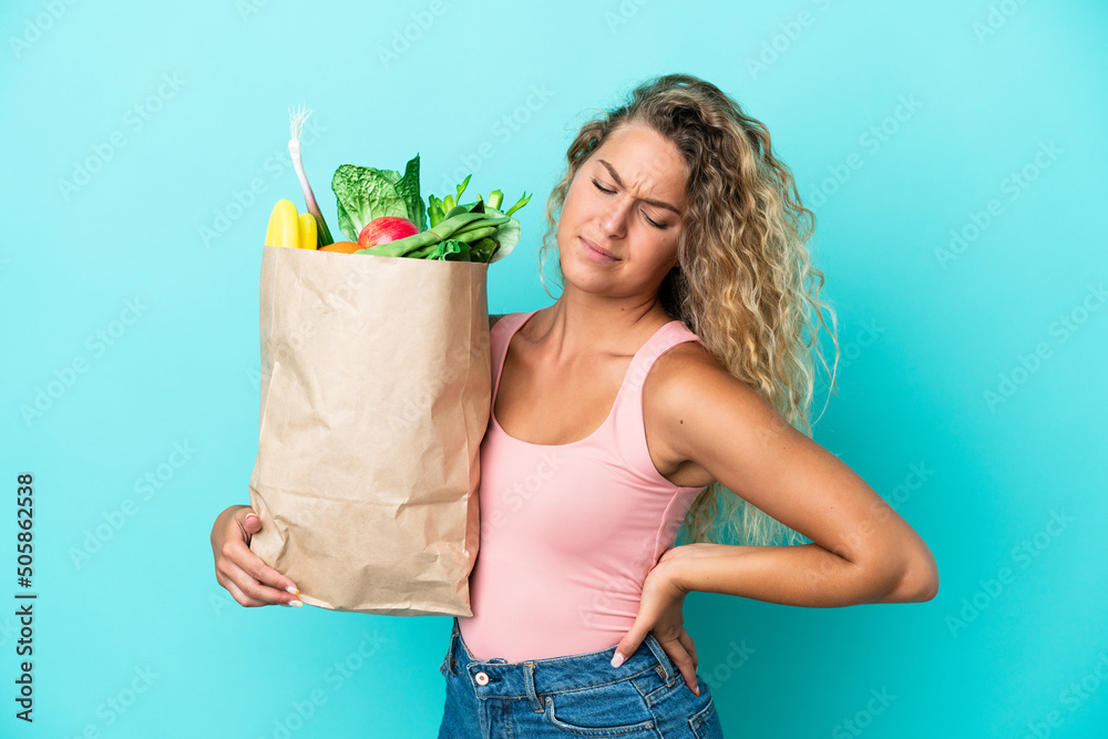 Φωτογραφία Girl with curly hair holding a grocery shopping bag isolated on green background