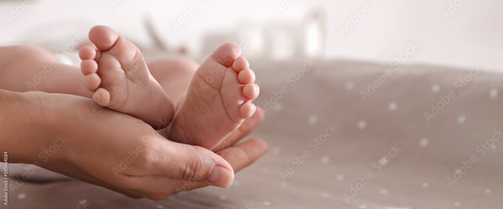 Fototapeta premium Mother and her little baby on bed, closeup view with space for text. Banner design