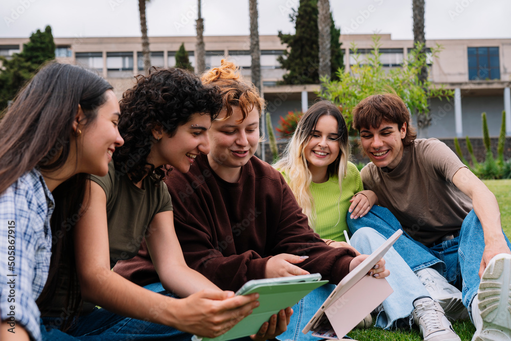 Group of college students taking photos on campus grass