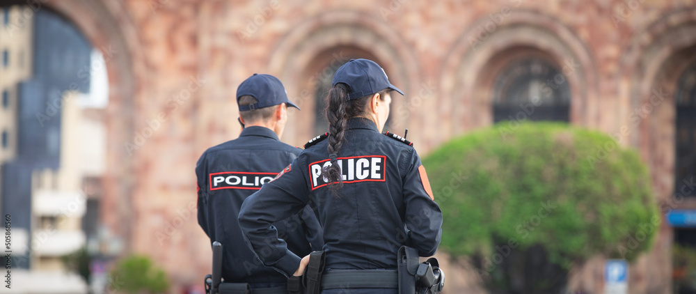 Φωτογραφία Caucasian man and woman police officers in the city.