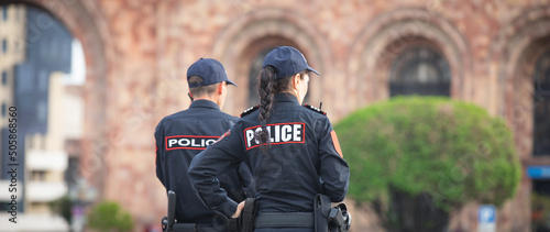 Bild auf Leinwand Caucasian man and woman police officers in the city.