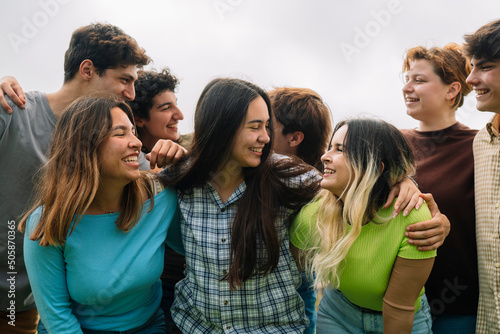 Group of college students smiling at each other campus