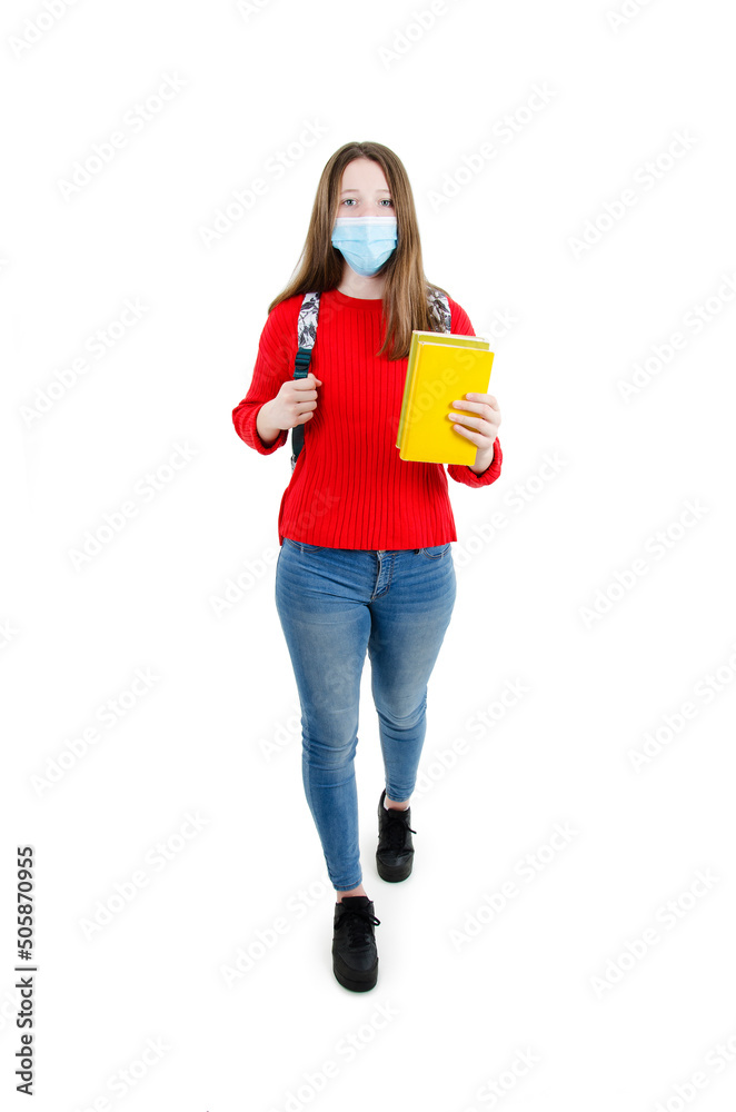 Φωτογραφία Young girl student, teenage girl in protective medical mask on face with backpack and books going to school