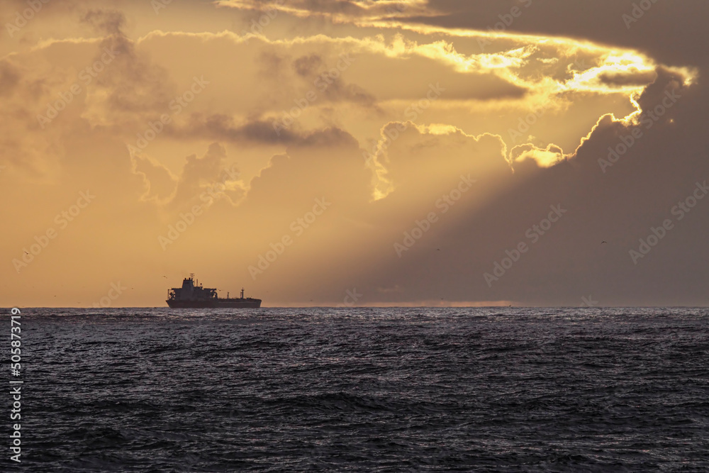 Ship on the horizon at orange sunset