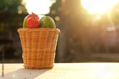 Fresh vegetables in a bamboo basket with sunlight.	