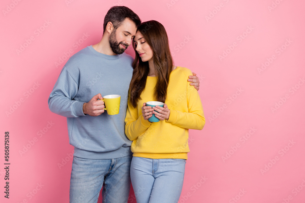 Portrait of two idyllic peaceful partners hug closed eyes hold tea mug isolated on pink color background - obrazy, fototapety, plakaty 