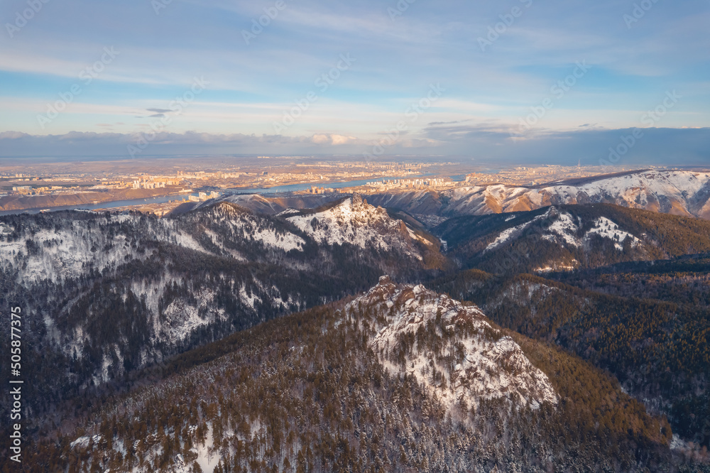 Aerial top view city Krasnoyarsk Russia taiga forest and rocks of stolby sanctuary, winter sunset Aerial top view city Krasnoyarsk Russia taiga forest and rocks of stolby sanctuary, winter sunset