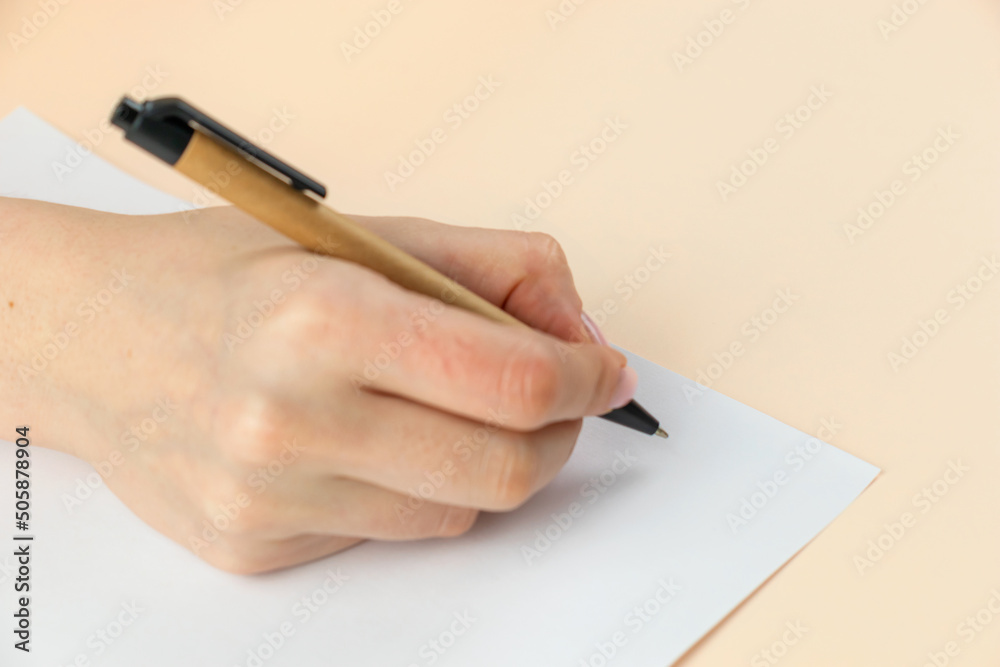 Closeup of woman's hand writing on paper, selective focus Closeup of woman's hand writing on paper, selective focus