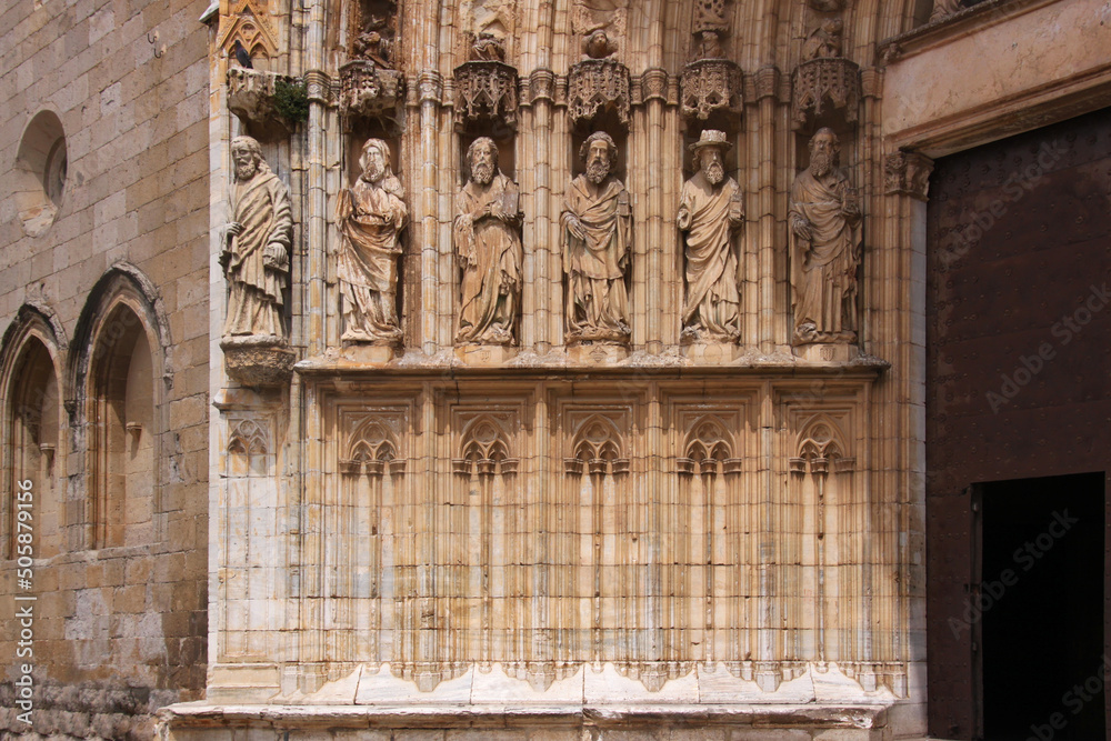 Gothic archivolt with lancet arches and sculptures of saints at the portal jamb of Castello d’Empuries city church, Catalonia in Spain