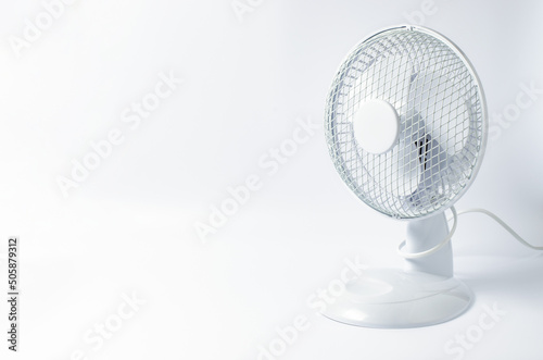 Table fan on white background. Cooling in the room in hot weather