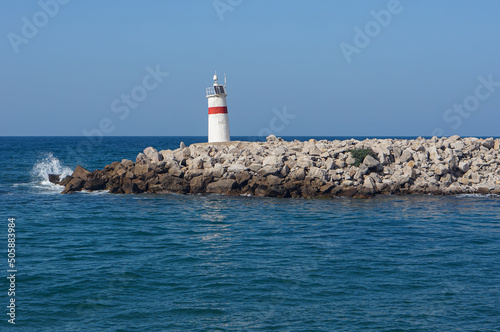 Small lighthouse building on the rocks with a wavy sea view. Summer morning. Copy space for text. No people. Town known as "Agva" in Sile, Black Sea part of Turkey.