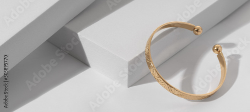 Fotografija Panoramic shot of a Modern gold bracelet with geometric pattern on minimalistic