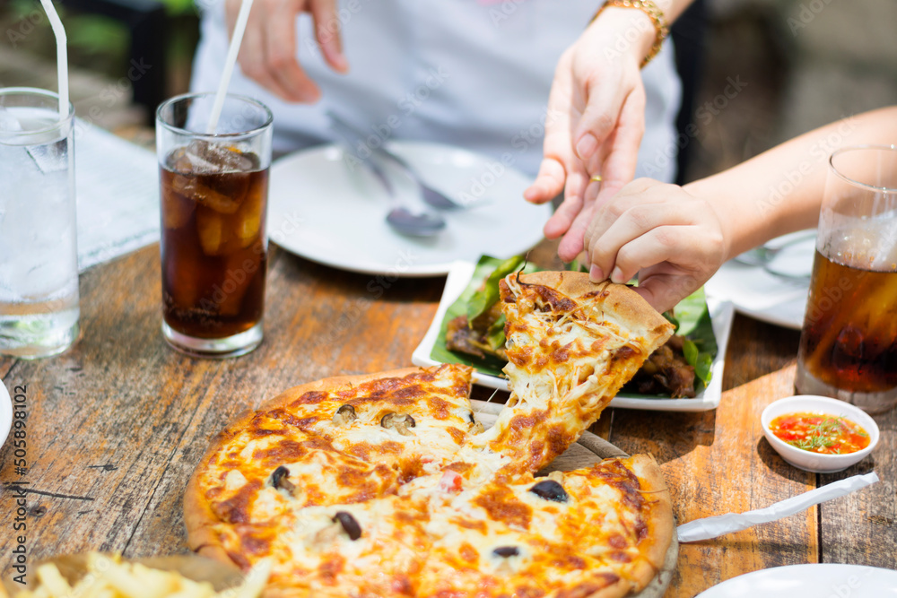 hand picking hot pizza with cheese delicious on the wooden table Rustic restaurant