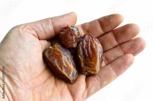 Organic fresh nutritious dried hurma dates medjool grains, on hand photo