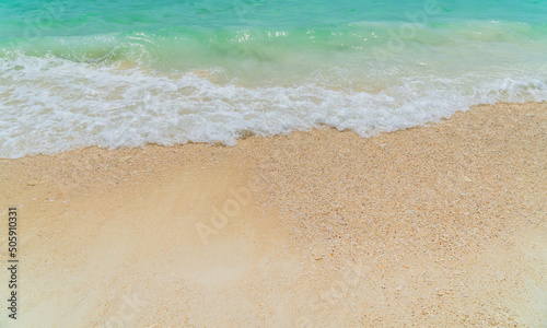 Sand beach seaside with white foamy from blue sea in summer season 