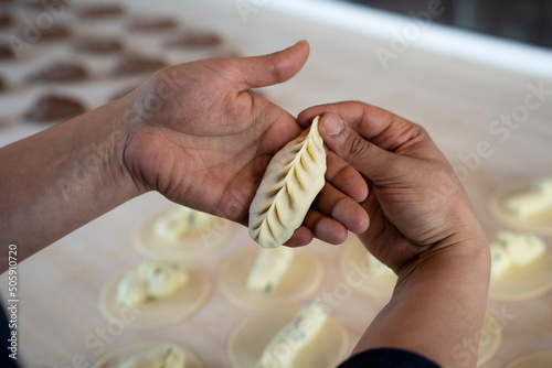 Close-up of female hands showing fresh homemade culurgiones pasta. Italian typical filled pasta from Sardinia region photo