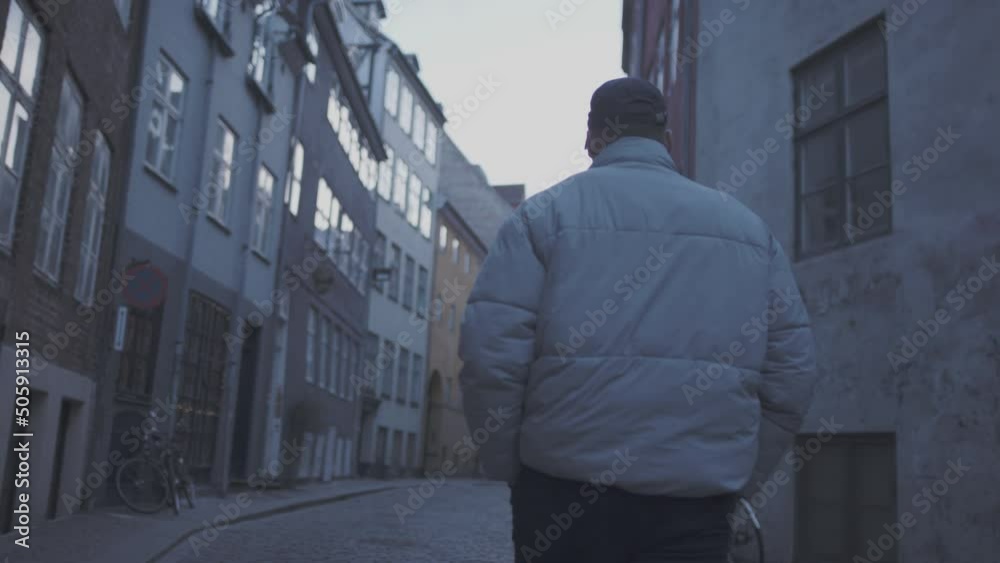 Guy in copenhagen in white jacket, walking down small city street. 60fps Guy in copenhagen in white jacket, walking down small city street. 60fps