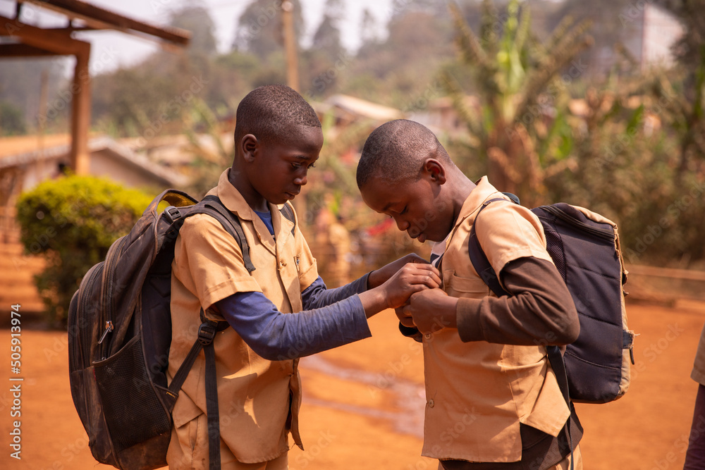 Foto de Two african children with their heavy backpacks play in the ...