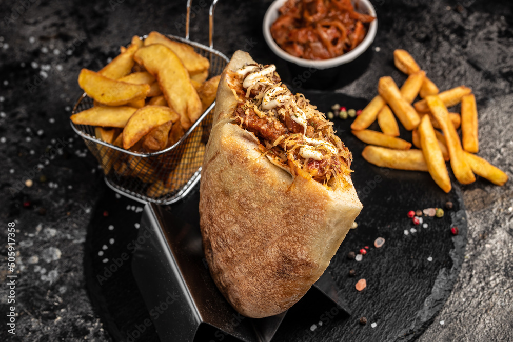 Φωτογραφία Kebab, pita, gyros, shaurma, wrap sandwich stuffed with sausages from minced meat with grilled meat, vegetables and sauce on dark background
