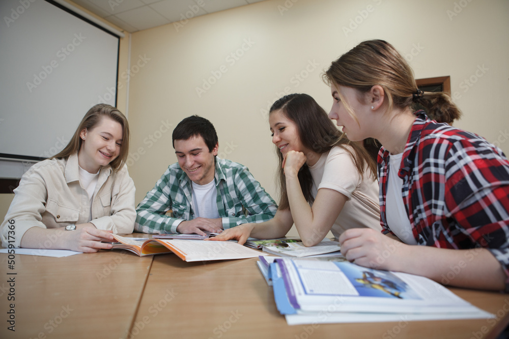 Group of college students talking in class Group of college students talking in class