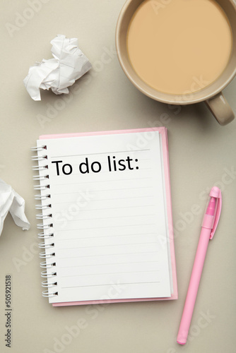 Coffee cup and notebook with to do list on grey background., planning and design concept