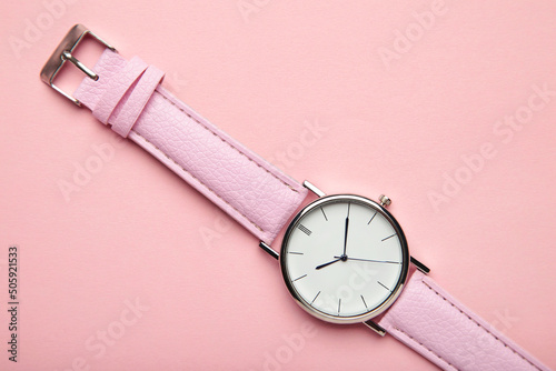Pink wrist watches on pink background with copy space
