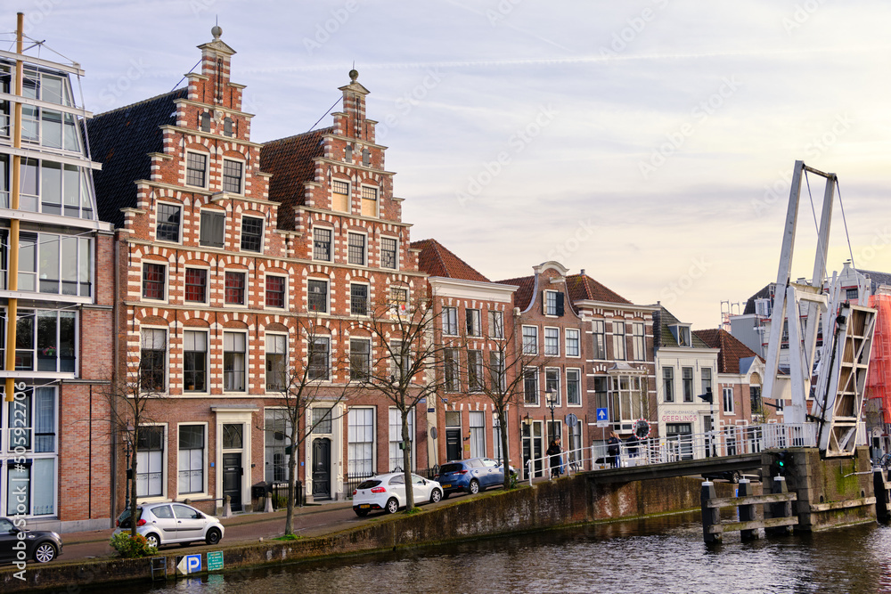 Haarlem, The Netherlands - April 11, 2022: Gravestenen drawbridge raised over Spaarne river with gable canal houses.