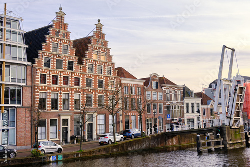 Haarlem, The Netherlands - April 11, 2022: Gravestenen drawbridge raised over Spaarne river with gable canal houses.