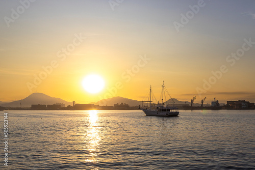 Veleiro barco no mar com o sol nascendo photo