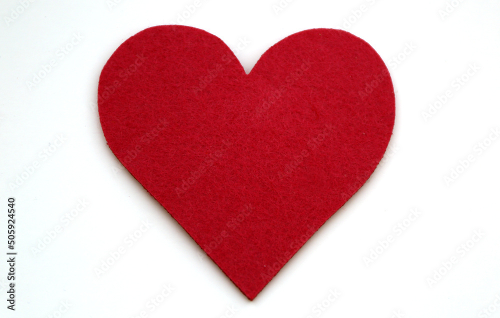 Red colored heart shape made of felt shot on white.