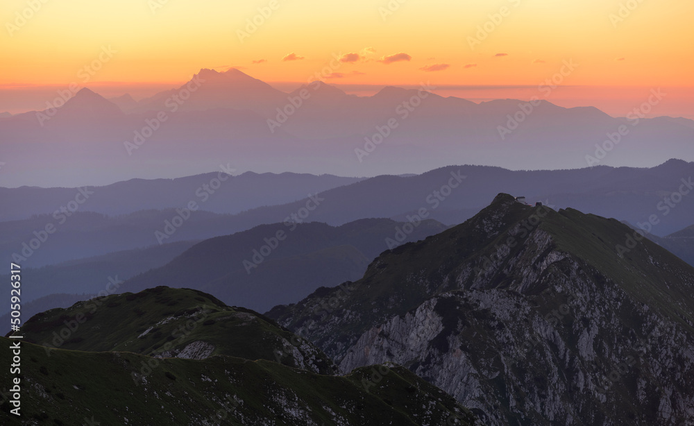 Sunrise mountains silhouette in the Julian Alps. Beautiful morning at the summit of the hills. 