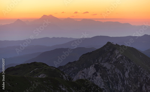 Sunrise mountains silhouette in the Julian Alps. Beautiful morning at the summit of the hills. 