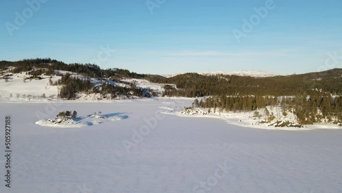 Aerial top view from drone of frozen lake, snow and forest in Rauland - Norway photo