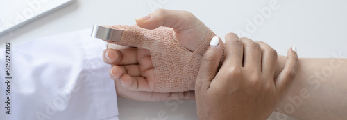 Doctor is looking at the patient's finger splint, finger straight with orthopedic device, Treatment or examination of the patient's condition.. photo