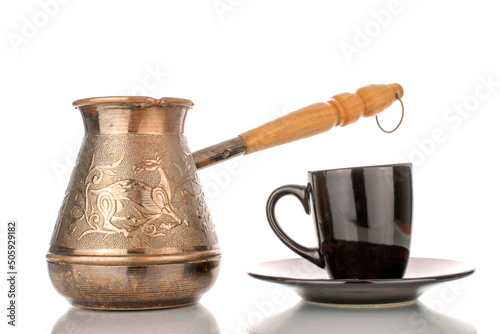One Turkish Cezve copper coffee pot with black ceramic cup, close-up, isolated on white background.