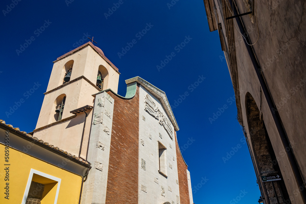 Obraz premium The small village of Tolfa, in Lazio. The church of Sant'Egidio Abatec with its bell tower. The facade in white travertine, with the figures of angels carved in bas-relief.