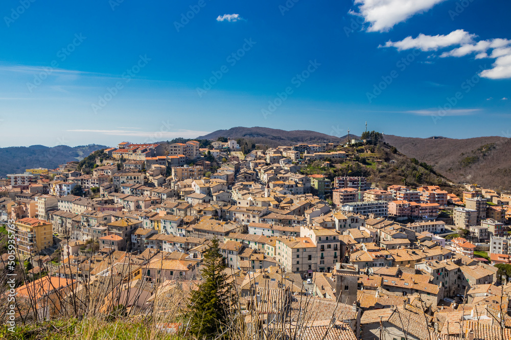 The small village of Tolfa, in Lazio. The view of the town perched on the mountain. Above, the church of the Capuchin monastery. The roofs of the houses with red and orange tiles.