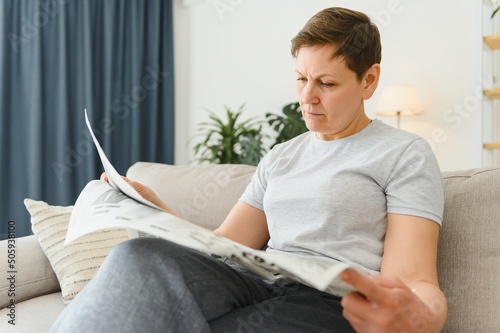 woman reading newspaper at home