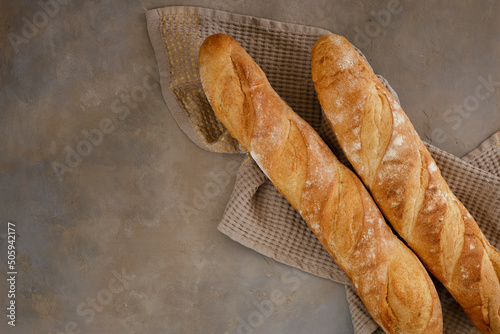 Fresh baguette with crispy crust on a concrete table