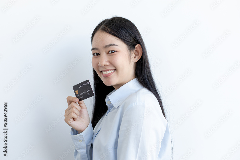 Young Asian business woman holding a credit card and smiling happily, Credit card purchases, Technology era concept. Young Asian business woman holding a credit card and smiling happily, Credit card purchases, Technology era concept.