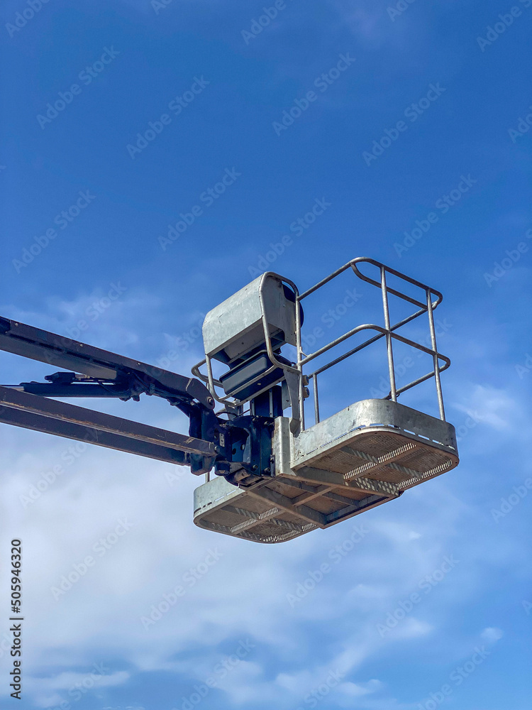 Lifting machine, work aerial platforms against blue sky Lifting machine, work aerial platforms against blue sky