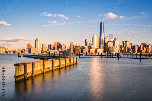 Downtown New York as observed from Jersey City, across the Hudson River. The Financial District skyscrapers have an orange glow under a bright sunset
