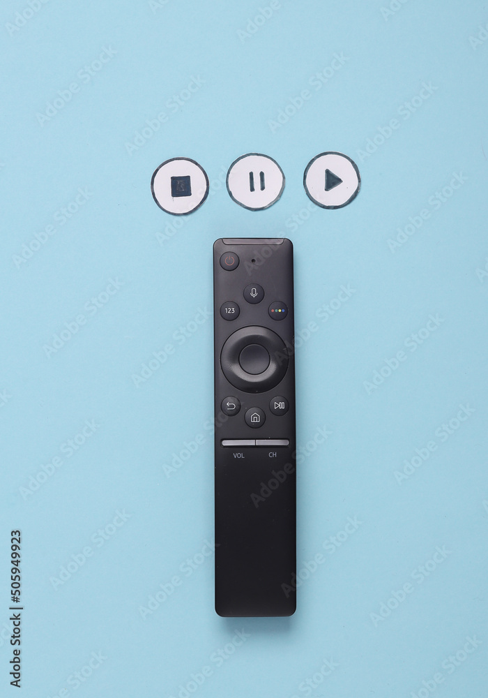 Tv remote with icons start, stop, pause of media player on blue background. Top view Tv remote with icons start, stop, pause of media player on blue background. Top view