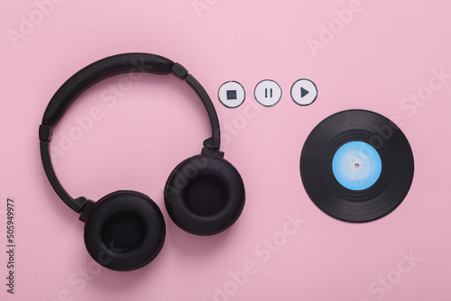Vinyl record and headphones with icons start, stop, pause of media player on pink background. Top view