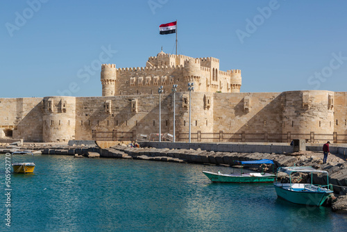 Alexandria, Egypt - January 2022: Citadel of Qaitbay fortress and a small lake with boats in front  photo