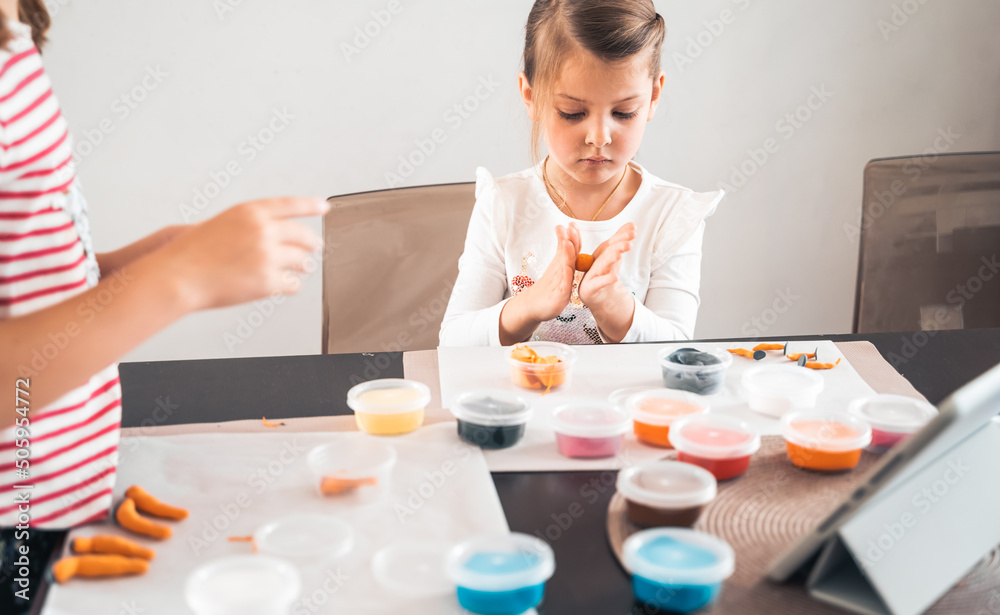 Little girls sculpt figurines crafts from air plasticine, modeling dough.Online lessons in tablet. Children's creativity,hobby,developing activities,training,development of fine motor skills of hands Little girls sculpt figurines crafts from air plasticine, modeling dough.Online lessons in tablet. Children's creativity,hobby,developing activities,training,development of fine motor skills of hands