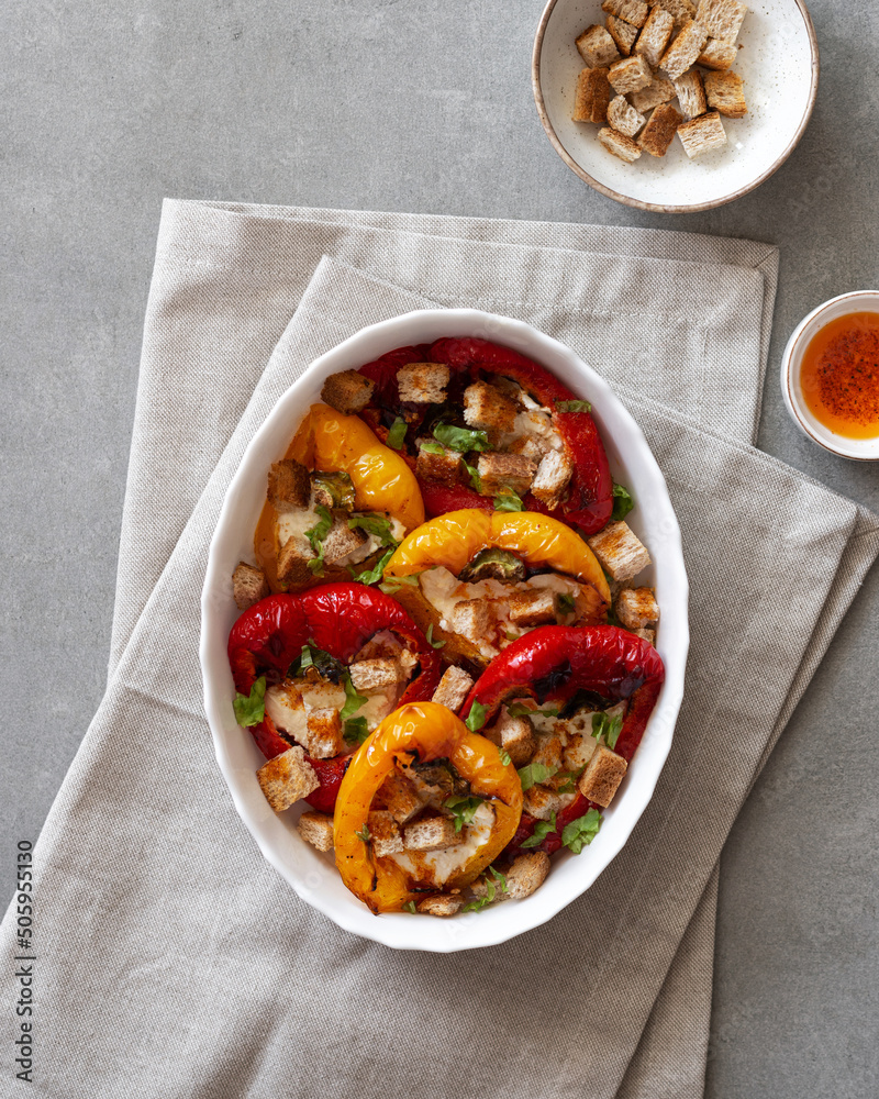 Baked peppers with cream cheese on a gray concrete background. Grilled colorful peppers with cream cheese and croutons. Delicious homemade picnic food Baked peppers with cream cheese on a gray concrete background. Grilled colorful peppers with cream cheese and croutons. Delicious homemade picnic food