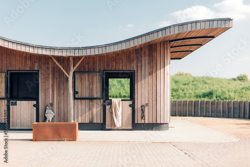design stables in a horse education center - modern horse farm with wooden and steel structures - daylight photo