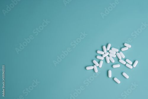 .Several white oblong-shaped tablets on a turquoise background
