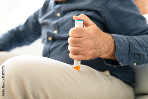Man Injecting Epinephrine Using Auto-injector Syringe photo